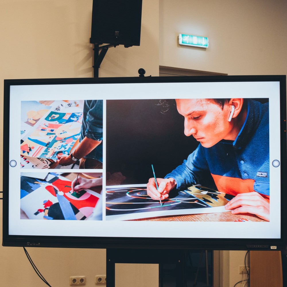 1728549517349 divi vīrieši sēž zāles priekšā